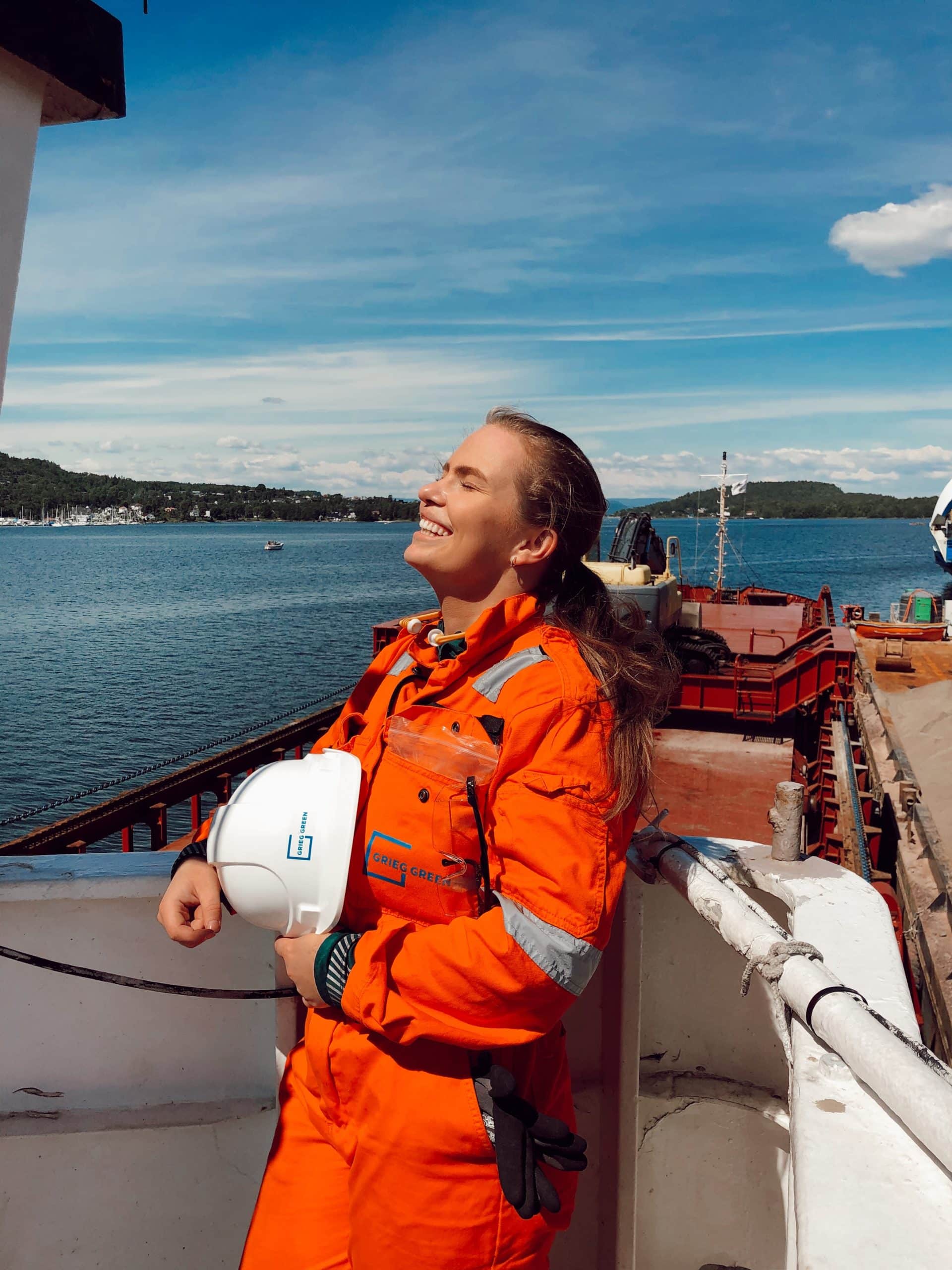 Female employee smiling in workwear at a boat - Malin Haugen, Grieg Green