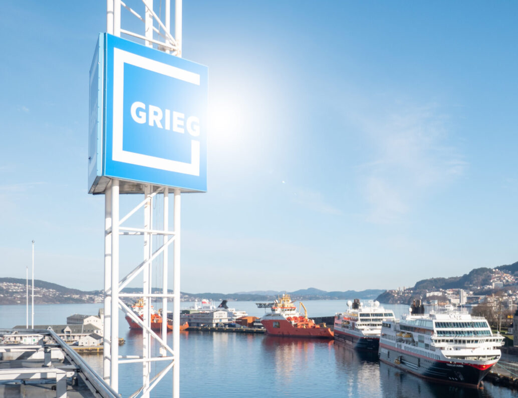 Grieg logo above the city sky in Bergen